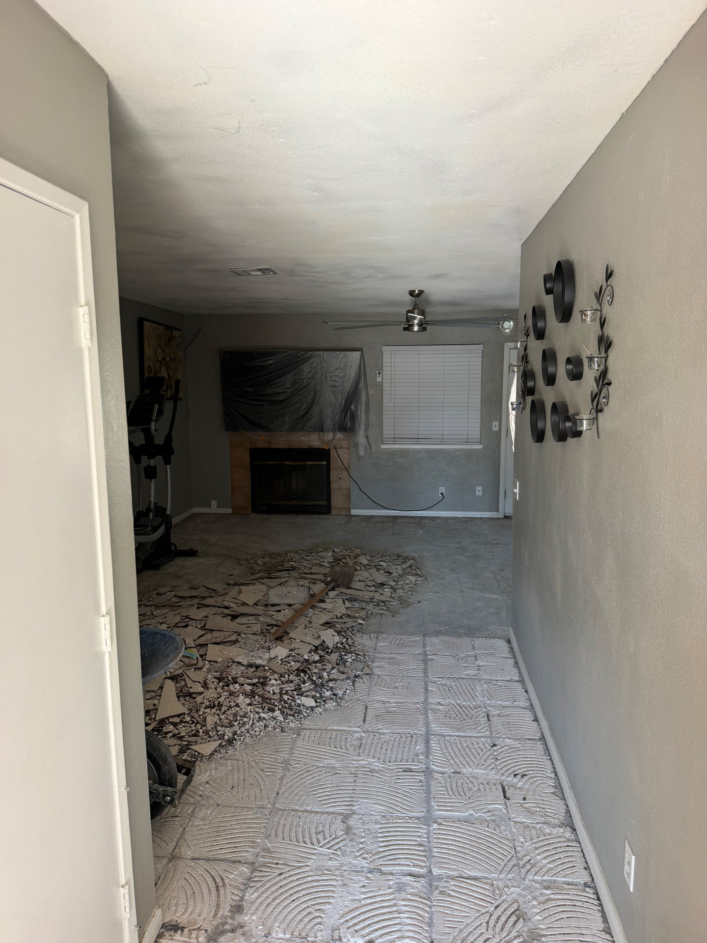 Room with old flooring torn out and a pile of demolition debris ready for hauling