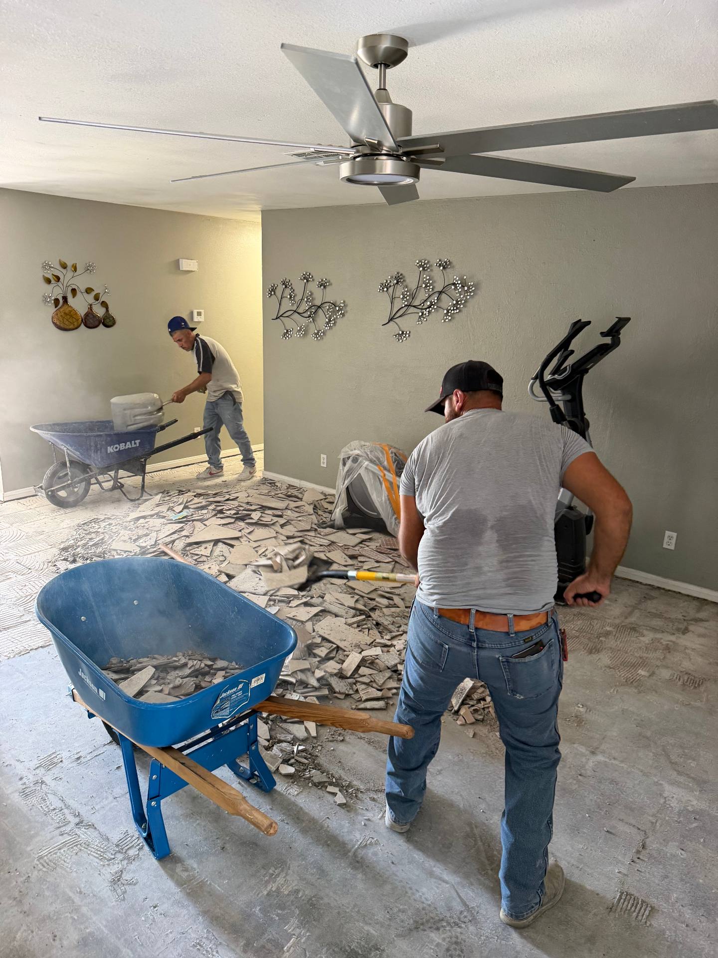 HG crew hauling tile demolition debris out of a home