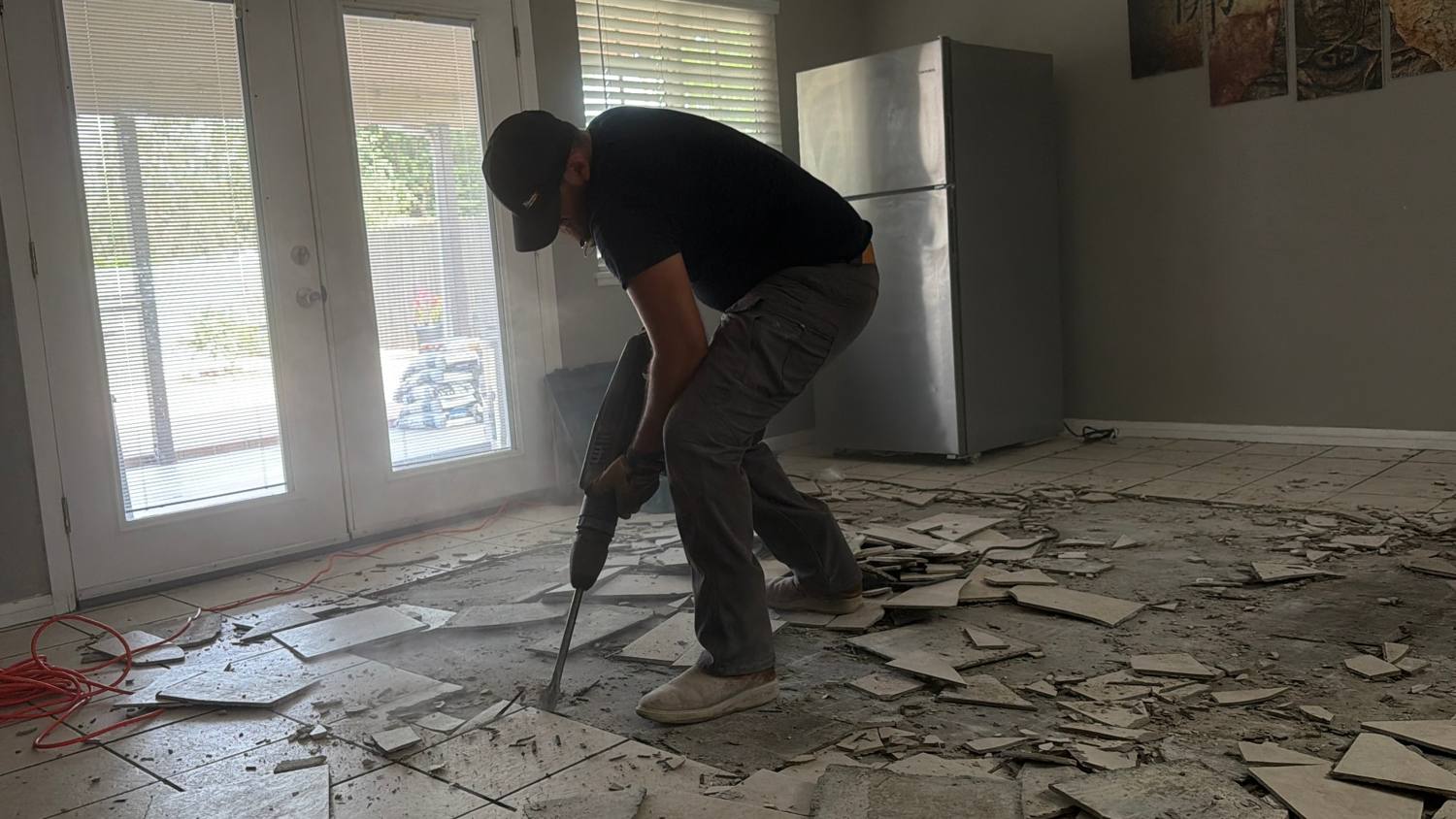 HG team member jackhammering old tile flooring during demolition